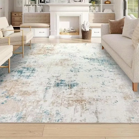 Cream and blue abstract washable rug in front of a fireplace
