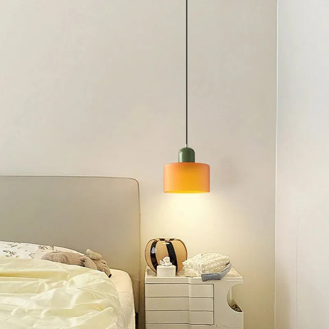 Amber glass pendant light over a white bedside table
