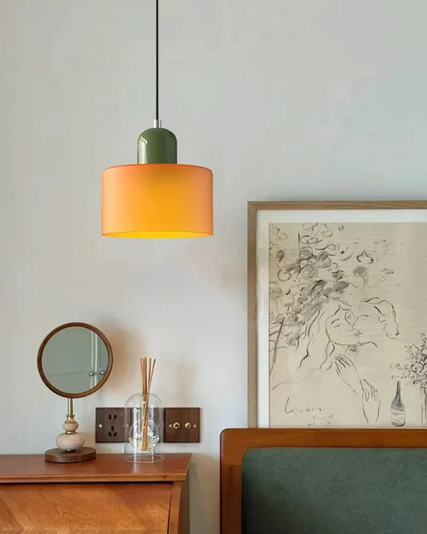 Amber glass pendant light above a wooden sideboard