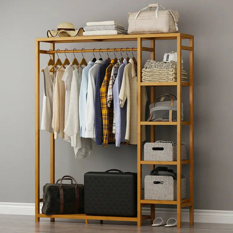 Bamboo garment rack with curtain holding hanging clothes and a suitcase