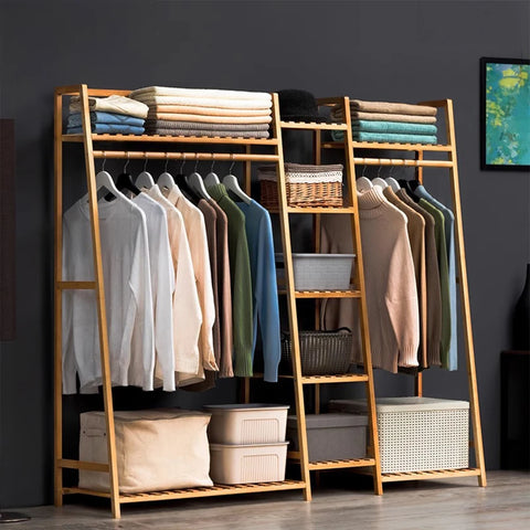 Bamboo ladder garment rack holding coats and folded items