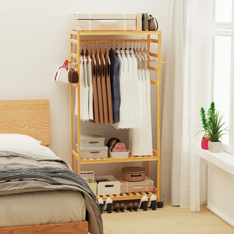 Bamboo rolling clothes rail beside a bed as open wardrobe storage