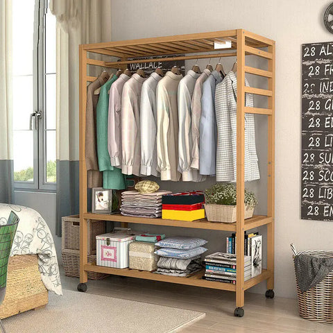 Bamboo rolling clothes rail hung with clothes and stacked with books
