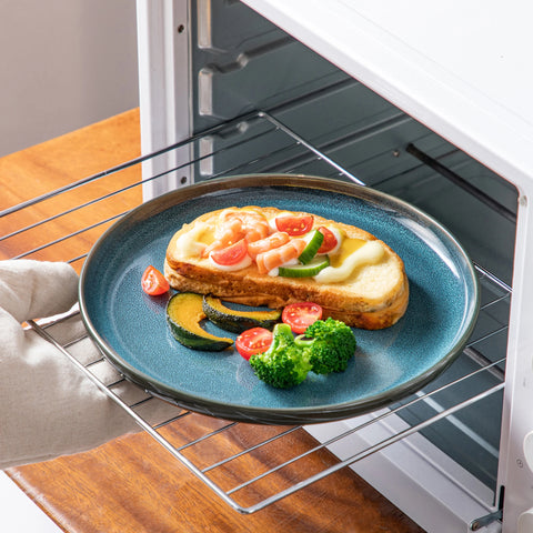 Teal reactive glaze plate on an oven shelf, showing it is oven safe