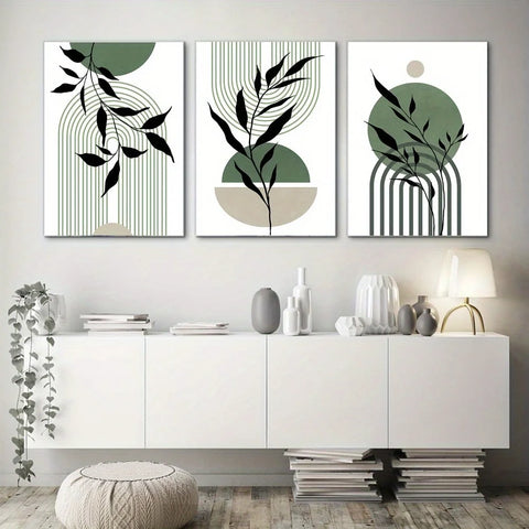 Three sage green and black prints hung above a white cabinet