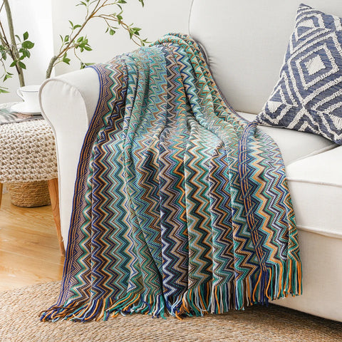 Blue boho tasselled throw over the arm of a white sofa
