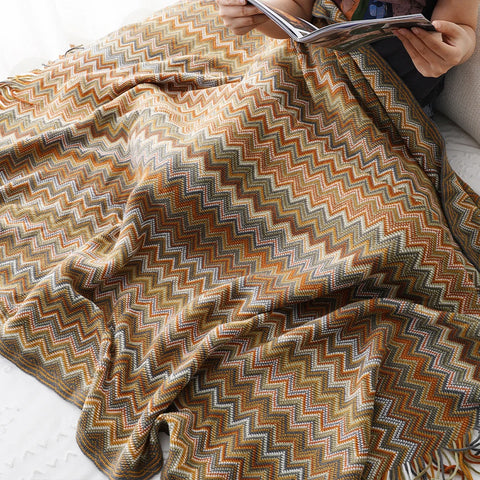 Mustard boho tasselled throw over a lap while reading