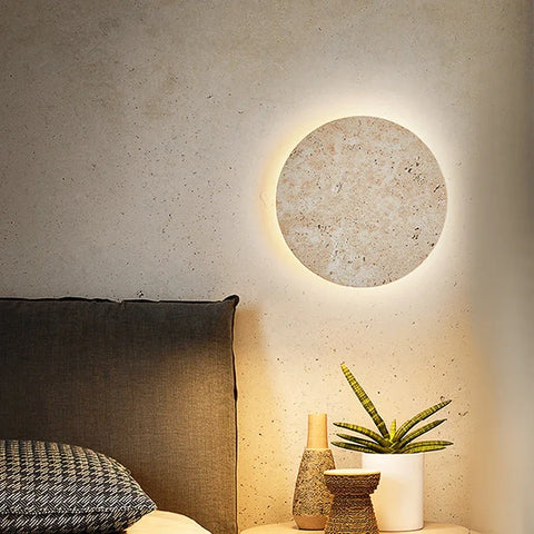 Cave stone wall light lit above a bed and plant