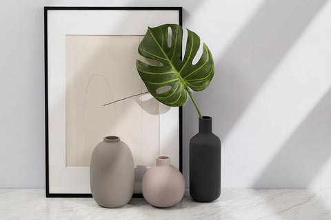 Three ceramic table vases beside a framed print