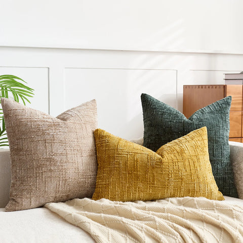 Chenille cushion covers in camel, teal and cream on a sofa