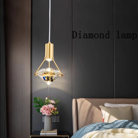 Copper and crystal pendant light beside a bed