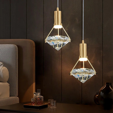 Two copper and crystal pendant lights lit against a dark wall