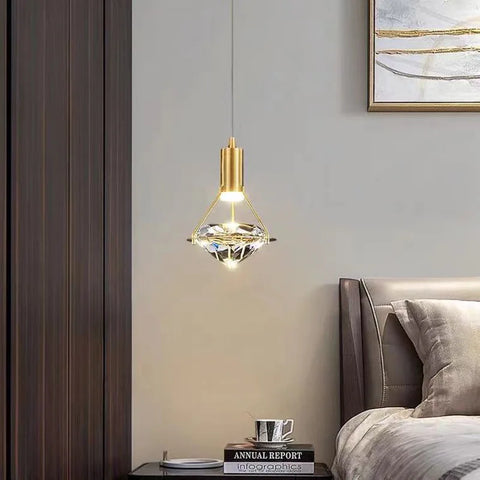 Copper and crystal pendant light over a bedside table