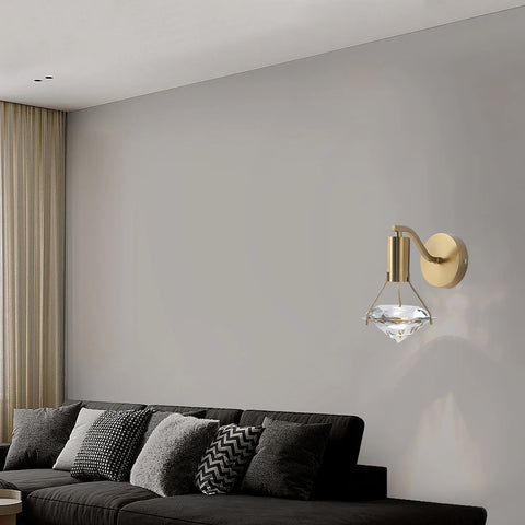 Copper and crystal wall light above a dark sofa