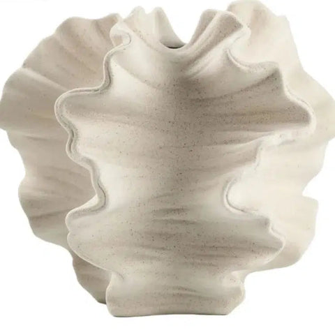 Coral ceramic vase on a plain background, side view of the fluted edges