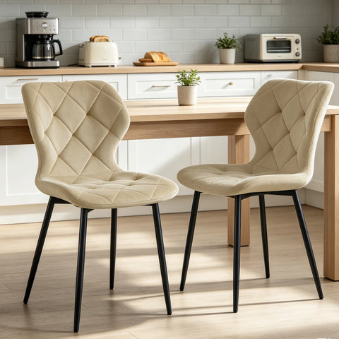 Two cream velvet curved back dining chairs in a kitchen