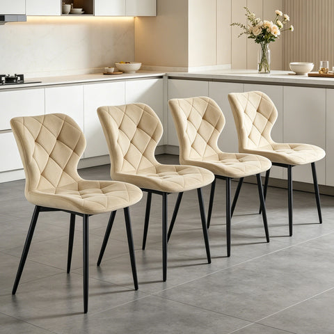 Set of four cream velvet curved back dining chairs in a kitchen