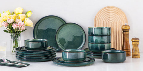 Full curved edge green dinner set stacked on a kitchen counter