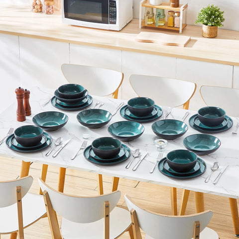 Blue reactive glaze plates and bowls laid along a table