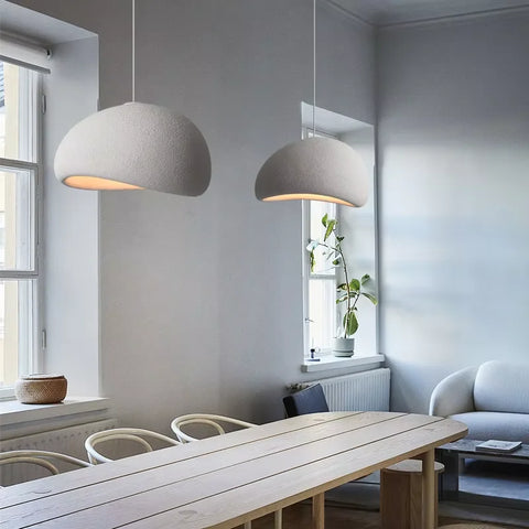 Dome pendant light above a dining table by a window