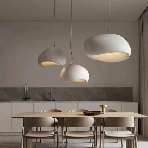 Three dome pendant lights hanging over a dining table
