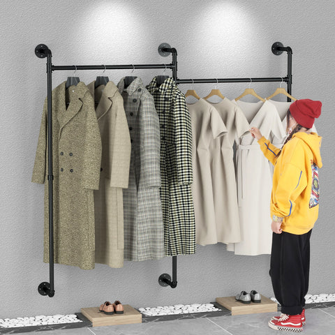 Wall-mounted pipe clothes rail used as open wardrobe storage in a bedroom