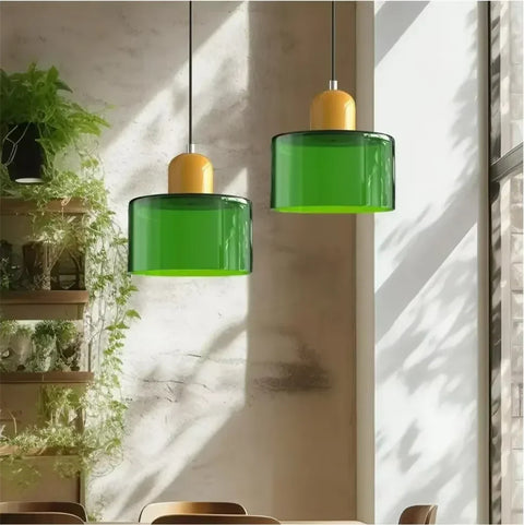 Pair of emerald glass pendant lights with mustard caps