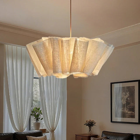 Pleated fabric chandelier lit in a bedroom