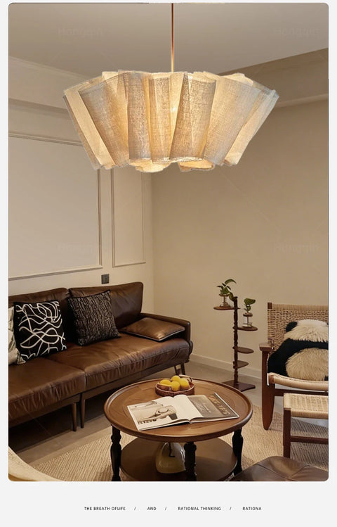 Pleated fabric chandelier in a living room with a brown sofa