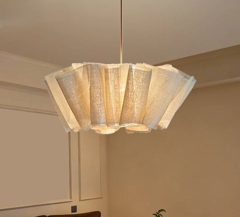 Pleated fabric chandelier lit above a dining area