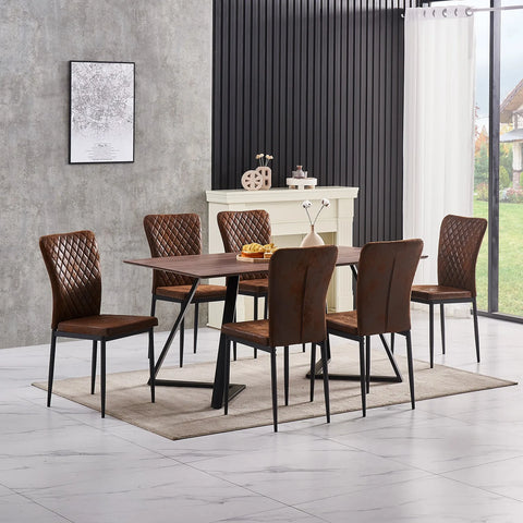 Brown faux suede dining chairs around a dining table by a window