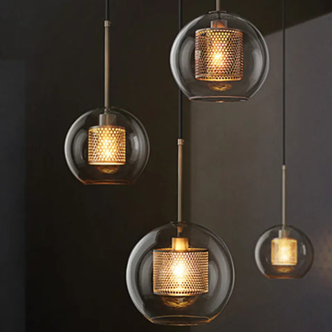 Three smoke glass globe pendants in different sizes, lit