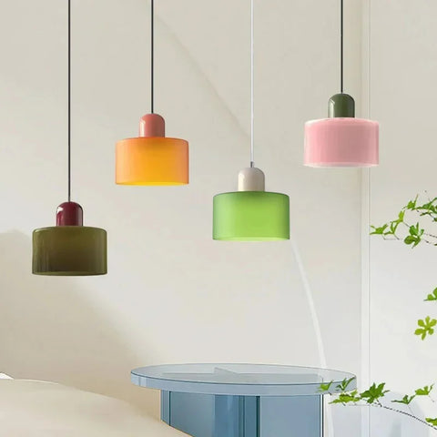 Khaki, amber, lime and pink glass pendant lights over a table