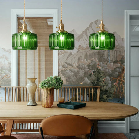 Three green glass pendant lights hung over a dining table