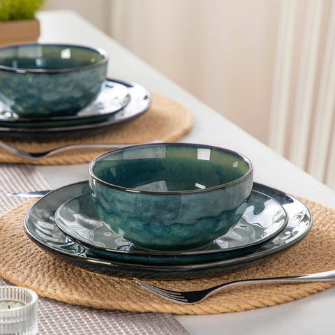 Green reactive glaze plates stacked on a wooden table