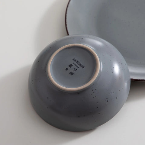 Grey stoneware bowls stacked, close view of the darker rim