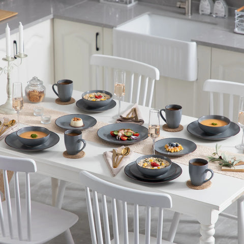 Grey stoneware plates and mugs set out on a dining table