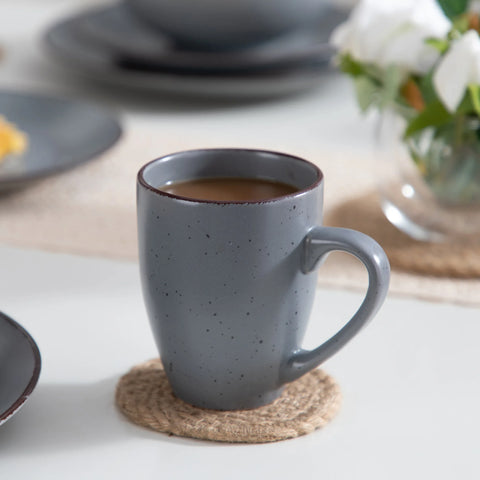 Grey stoneware mug of coffee on a woven coaster