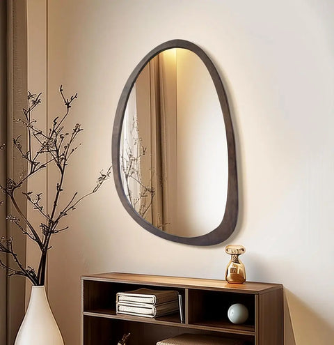 Irregular walnut wall mirror hung above a low sideboard