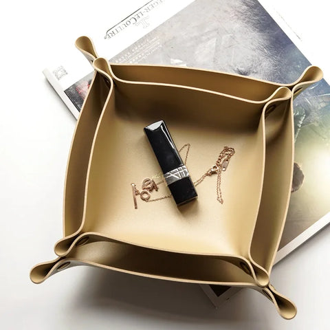 Gold leather valet tray holding a lipstick