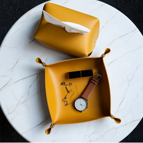 Yellow leather valet trays holding a watch and glasses