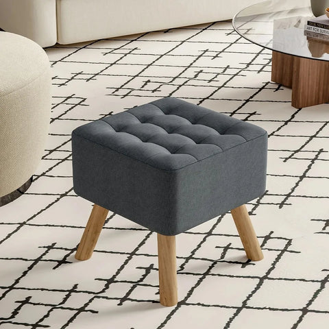 Dark grey quilted linen footstool on splayed pine legs