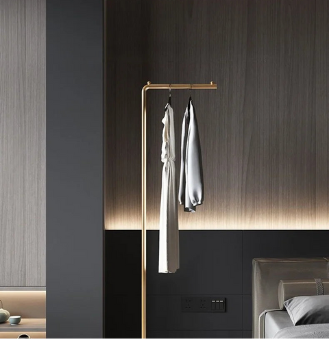 Gold valet stand in a dark bedroom