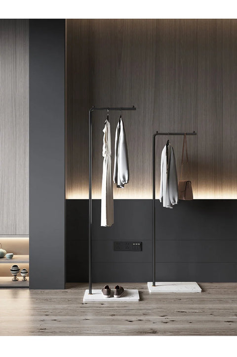 Two valet stands holding clothes in a bedroom