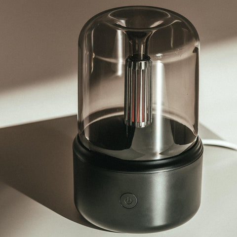 Mistt aroma diffuser in black on a table, with the control button on the base