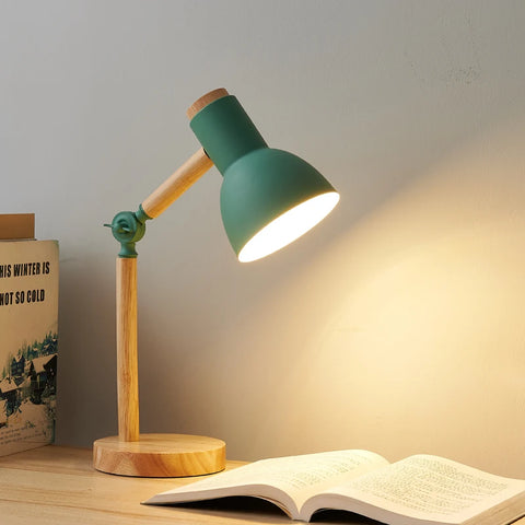 Green Nordic wooden desk lamp lit over an open book