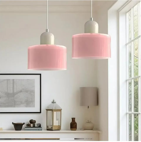 Pair of pink glass pendant lights by a window