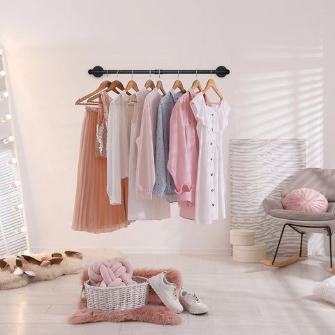 Pipe clothes rail hung with dresses and wooden hangers
