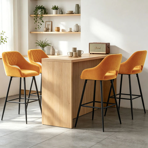 Four amber velvet quilted bar stools with arms at a wooden counter