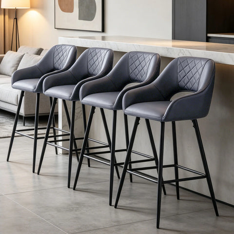 Four grey quilted bar stools with arms along a kitchen island